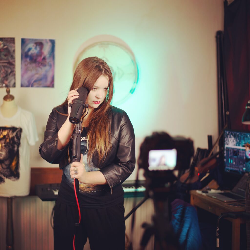 Ethereal Kingdoms vocal playthrough of Endings from Hollow Mirror. Behind the scenes. Sofia Schmidt leaning agains microphone stand in rehearsal room. 